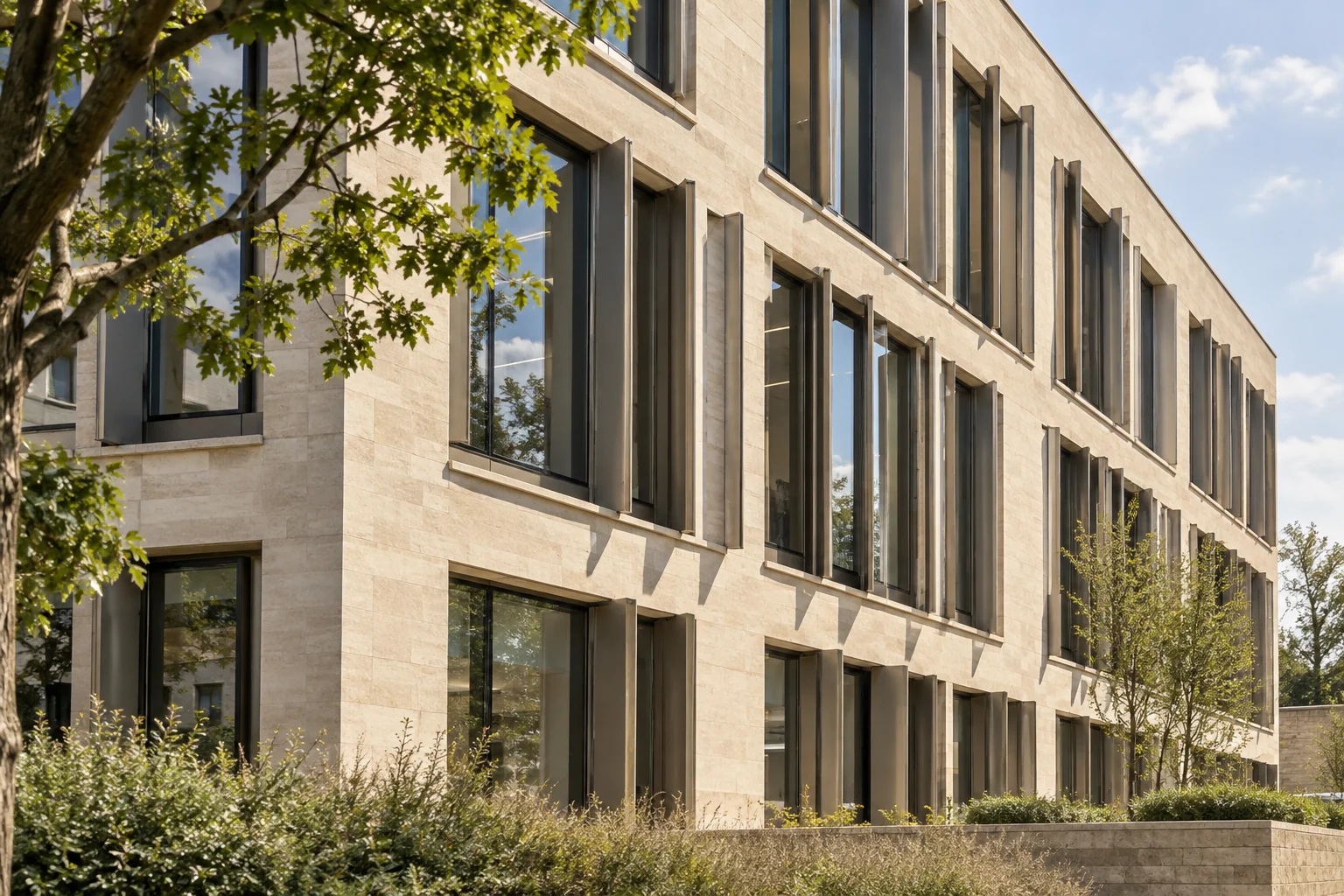 Vertical shading fins across the windows of a pale-stone building